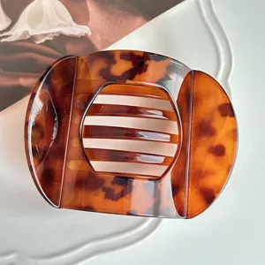 Close-up detail of vintage tortoiseshell hair claw clip, elegant tortoise shell pattern design for styling.