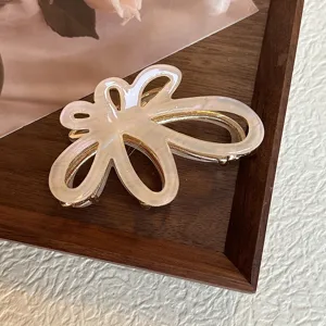 Vista dettagliata della molletta per capelli in acetato con fiore cavo, design bianco.