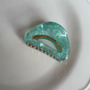 Gedetailleerd overzicht van een trendy groene acetaat haarklem met zeemeermin glans.