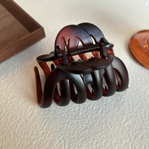 Brown tortoiseshell hair claw clip detail, elegant hollow design with durable metal spring.