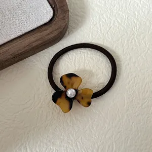 Close-up detail shot of a French vintage tortoiseshell acetate flower hair tie with pearl.