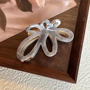 Primo piano dettagliato del fermaglio per capelli grigio marmorizzato dal design floreale.