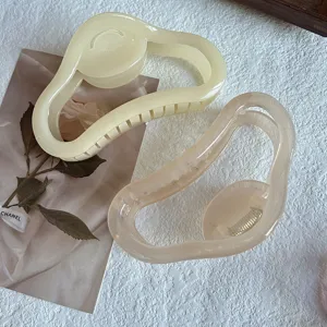 Große unregelmäßige Haarklammer Detailaufnahme, elegantes Acryl-Design für Damenfrisuren.
