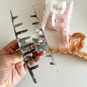 Detail view of large hair claw with marble pattern, ideal shark clip for thick hair updos.