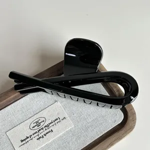 Elegant black hair claw clip detail shot, glossy finish, secure hold for thick hair everyday styling.