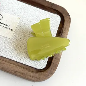 Green acetate carrot hair claw clip detail shot, cute jelly style side bangs clip texture.