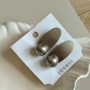 Exquisite metal oval and round ball hair clip detail shot, elegant side bang accessory.