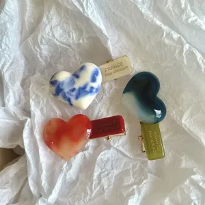 Close-up detail of stylish acetate heart hair clips with duckbill design for elegant daily wear.