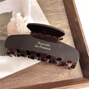 Brown acetate hair claw clip close-up detail, elegant French style hair accessory for women