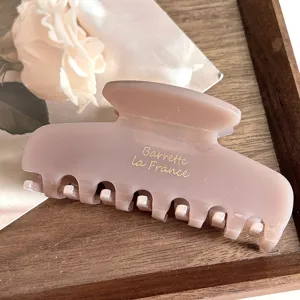 Elegant acetate hair claw clip with French style lettering, minimalist retro design for women.