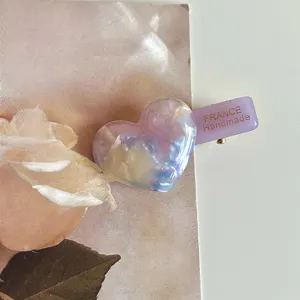 Sweet acetate heart hair clip detail shot, elegant side hairpin accessory for women.