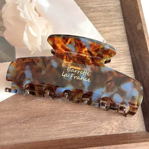 Detailed close-up of the elegant acetate hair claw featuring a vintage tortoise shell pattern.