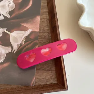 Pink acetate hair clip featuring cute hollow heart details. Perfect sweet style side clip.