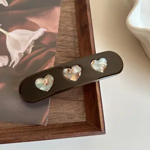Cute heart acetate hair clip detail shot, dark brown barrette with hollow hearts.