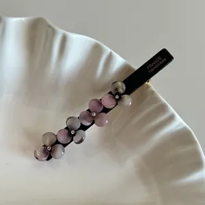 Detailed view of a elegant acetate flower hair clip, black duckbill clip with purple petals.