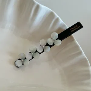 Elegant black acetate hair clip with translucent flowers and sparkly rhinestones for women.