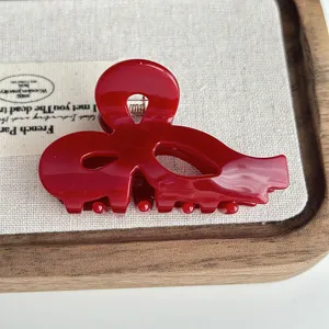 Red acetate bow hair claw clip for women, stylish hollow shark hair accessory for daily use.