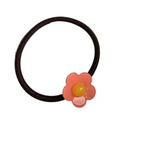 Chouchou floral doux avec jolie fleur rose et centre jaune, idéal pour le style quotidien.