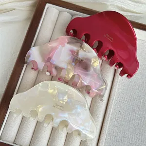 Gros plan détaillé de pinces à cheveux élégantes en acétate rouge, rose et blanc chic.