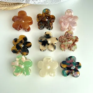 Detailed view of colorful floral hair claws, fashionable acetate material, elegant hair accessories.