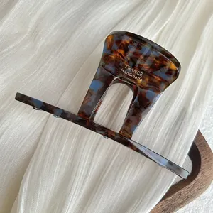 Detailed shot of vintage acetate flat hair claw clip with elegant tortoiseshell pattern and texture.