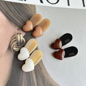 Detailed shot of cute heart hair clips showcasing glossy surface and secure duckbill clasp design.
