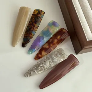 Close-up detail shot of elegant acetate hair clips featuring various patterns and smooth texture.