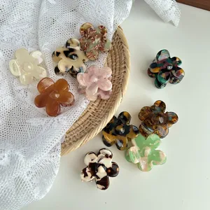 Detailed view of fashionable marble flower hair claws with glossy acetate finish and secure grip.