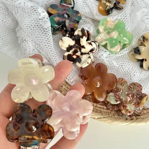 Detailed close-up of colorful floral hair claw clips with resin marbled tortoise patterns.