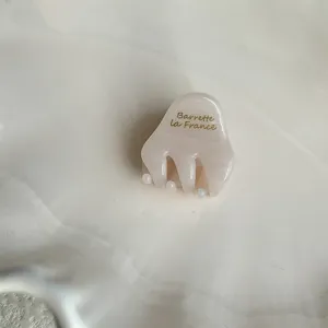 Detailed close-up of the mini acetate hair claw clip with golden lettering for sweet styling.