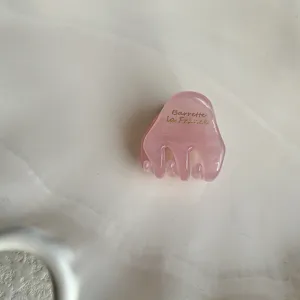 Mini pink acetate hair claw clip, cute small hair accessory for styling side bangs and fringe.
