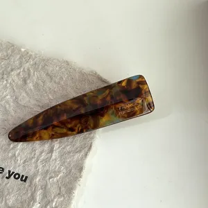 Detailed view of acetate hair clip, elegant tortoiseshell pattern side barrette for women.