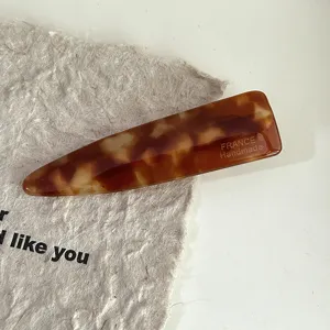 Acetate tortoiseshell hair clip detail view, elegant brown pattern side pin for women.
