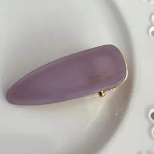 Close-up detail view of the elegant purple acetate hairpin with gold trim and textured surface.