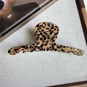 Detailed shot of a stylish leopard print hair claw clip showcasing its elegant curved design.