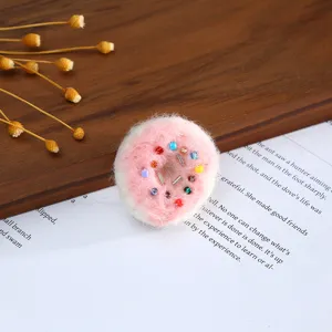 Handmade felt donut charm with colorful beads for DIY crafts and hair accessories detail.