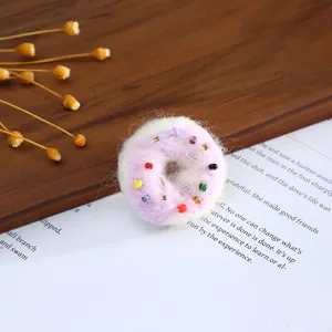 Wool felt donut shape craft detail view with colorful bead embellishments for DIY decoration.