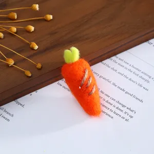 Detailed close-up of a cute orange wool felt carrot craft accessory with green top.