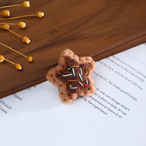 Close-up of handmade wool felt star with embroidery and beads for DIY hair accessories.