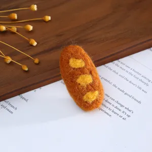 Handmade wool felt baguette bread charm for DIY cute hair clips, hats, and stylish clothing decor.