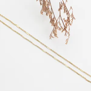 Minimalist gold chain necklace detail shot, delicate stackable stainless steel jewelry.