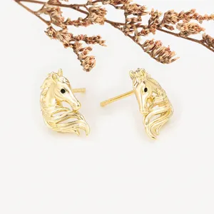 Close-up detail of stylish gold horse head stud earrings showcasing exquisite craftsmanship.