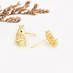 Gold-plated horse head stud earrings detail, exquisite metal texture, elegant daily jewelry.