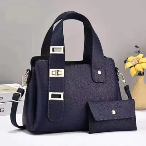 Gros plan sur le sac à main bleu marine avec sangle à boucle métallique et pochette assortie.
