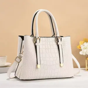 Vista dettagliata borsa bianca motivo coccodrillo, fibbie eleganti e tracolla in primo piano.