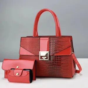 Rode lakleren handtas met krokodillenprint, gouden metalen sluiting en praktische schouderriem.