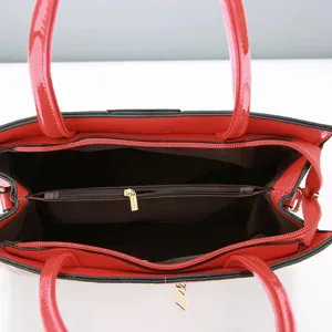 Close-up weergave met het ruime binnenvak en het handige vak met ritssluiting van de rode handtas.