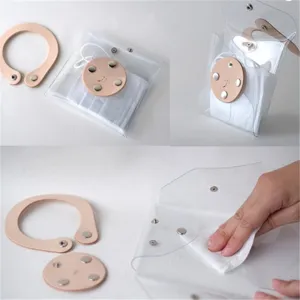 Transparent PVC mask storage bag with leather snap closure, portable dustproof pouch.