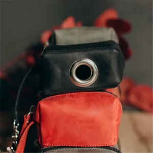 Leather dog waste bag dispenser and poop bag holder pouch with metal grommet detail.
