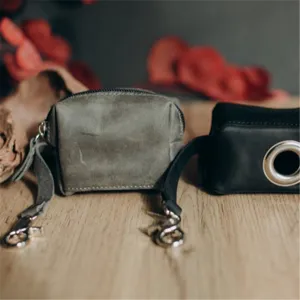 Leather dog waste bag dispenser holder with metal clasp and keyring for pet walking.